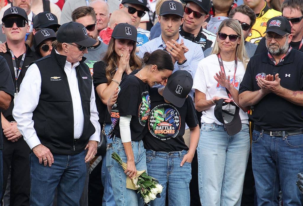 Kyle Busch's wife, Samantha Busch, and his son, Brexton Busch embrace one another on the grid during the remembrance ceremony for Kyle Busch, who passed away suddenly at the age of 41, 