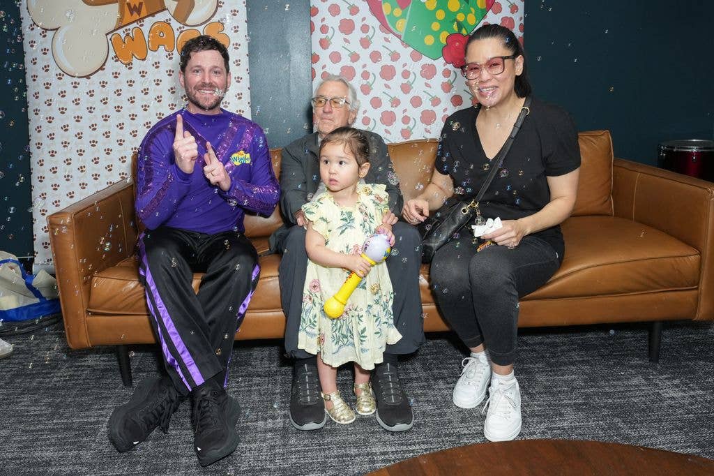Robert De Niro, Tiffany Chen and Gia Virginia Chen-De Niro sit on a leather sofa to meet Lachlan Gillespie from The Wiggles.