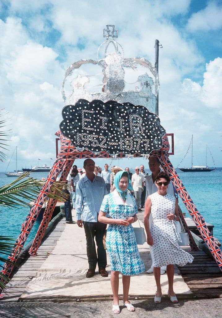Queen Elizabeth II arrives in Mustique, welcomed on a pier by her sister Princess Margaret in 1977.