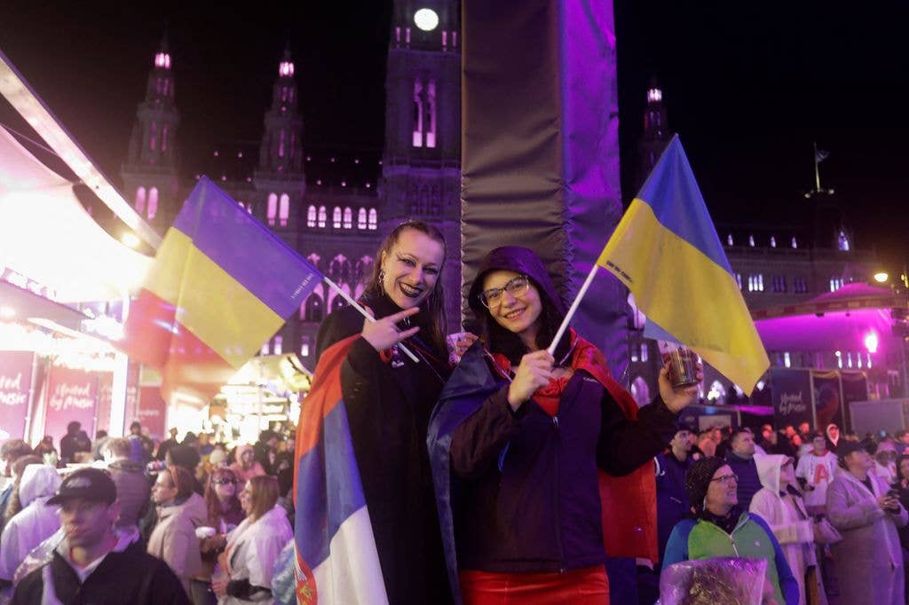 Fans with Romanian and Ukrainian flags cheer at the fan area 