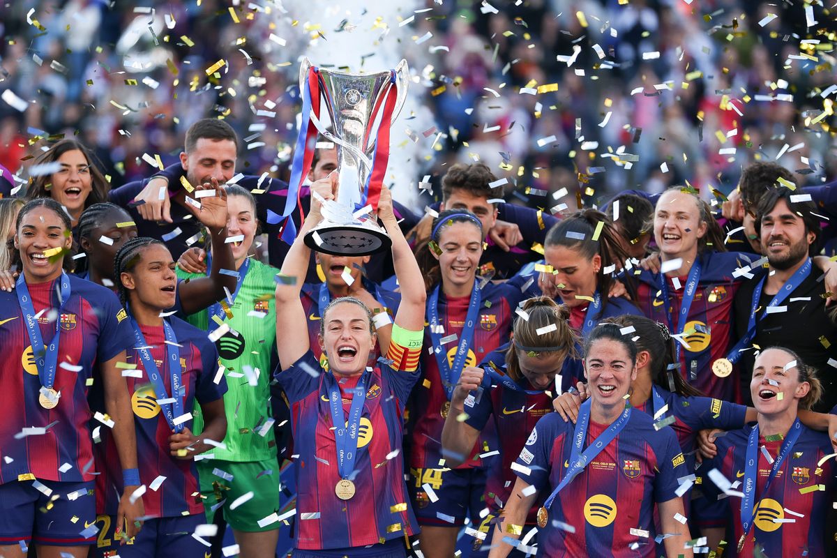 Alexia Putellas lifts the UEFA Women's Champions League trophy with teammates.
