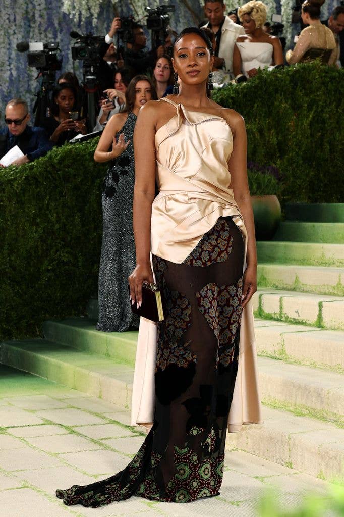 Naomi Elizee wore a gold and black dress with lace skirt
