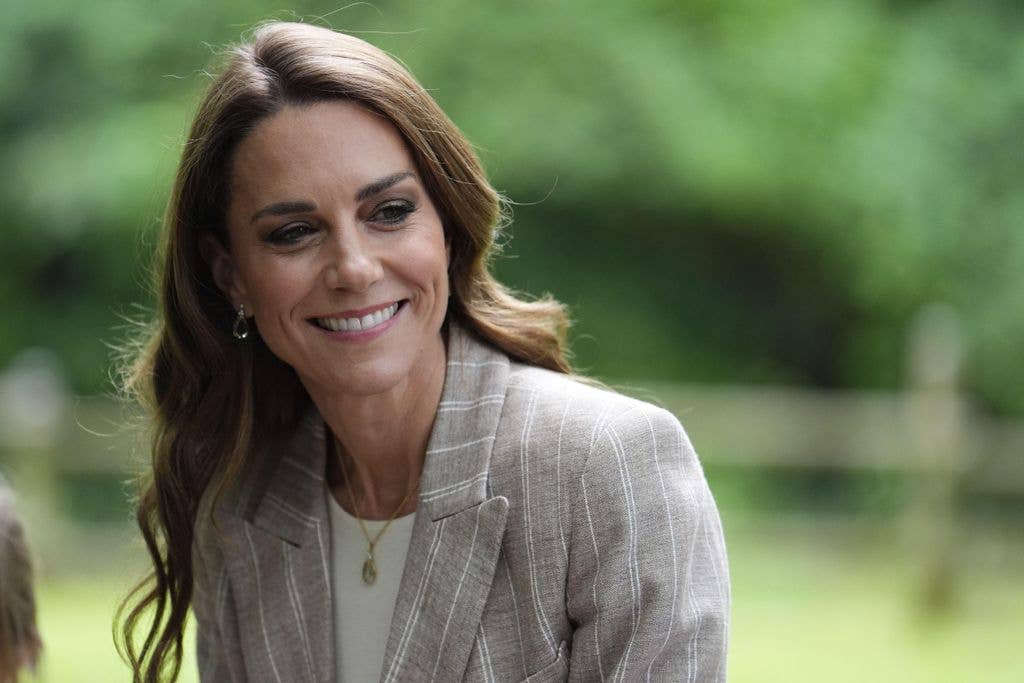 Kate Middleton smiling in a forest