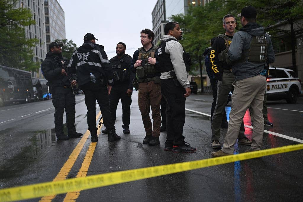 Armed police stand on a blocked street near a crime scene near the White House 