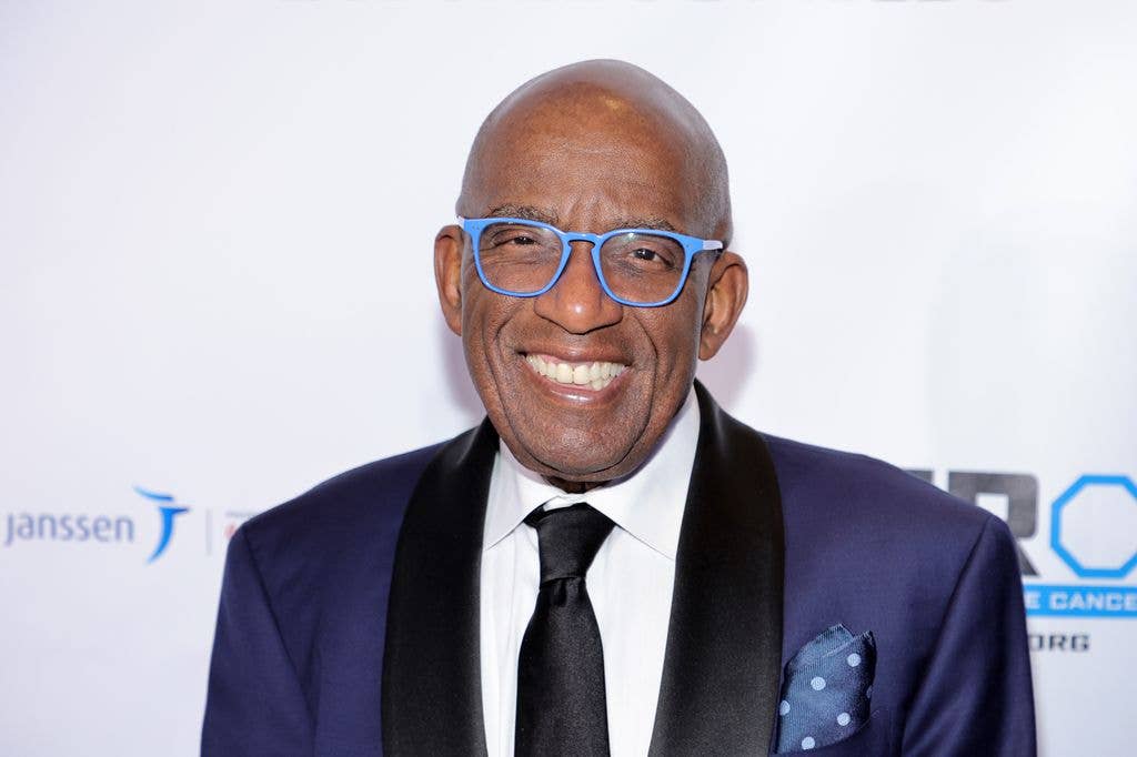 Al Roker in a purple satin suit wearing blue rimmed glasses