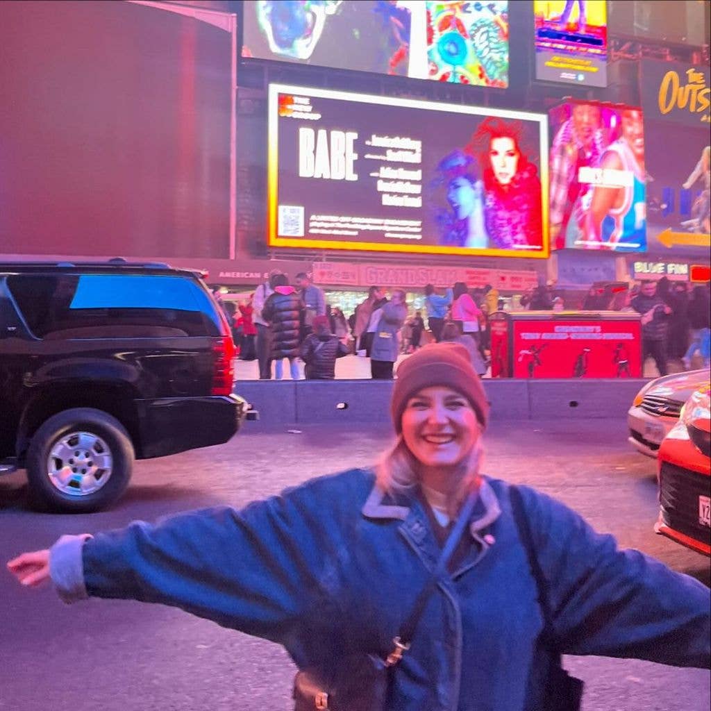 Gracie McGraw stands in front of the opening sign for "Babe" in Times Square, photo shared on Instagram