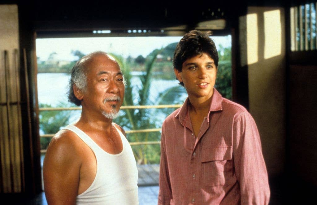 Pat Morita and Ralph Macchio stand together as Mr Miyagi and the titular Karate Kid.