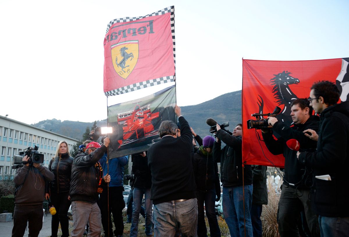 Fans display Ferrari flags as they gather outside the Grenoble University Hospital Centre in the French Alps, where retired seven-time German Formula One world champion Michael Schumacher was in critical condition after an off-piste skiing accident. 