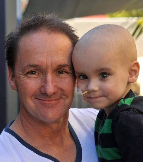 Rick Parish holds his son Eliot, who has a feeding tube in his nose as part of his treatment for cancer