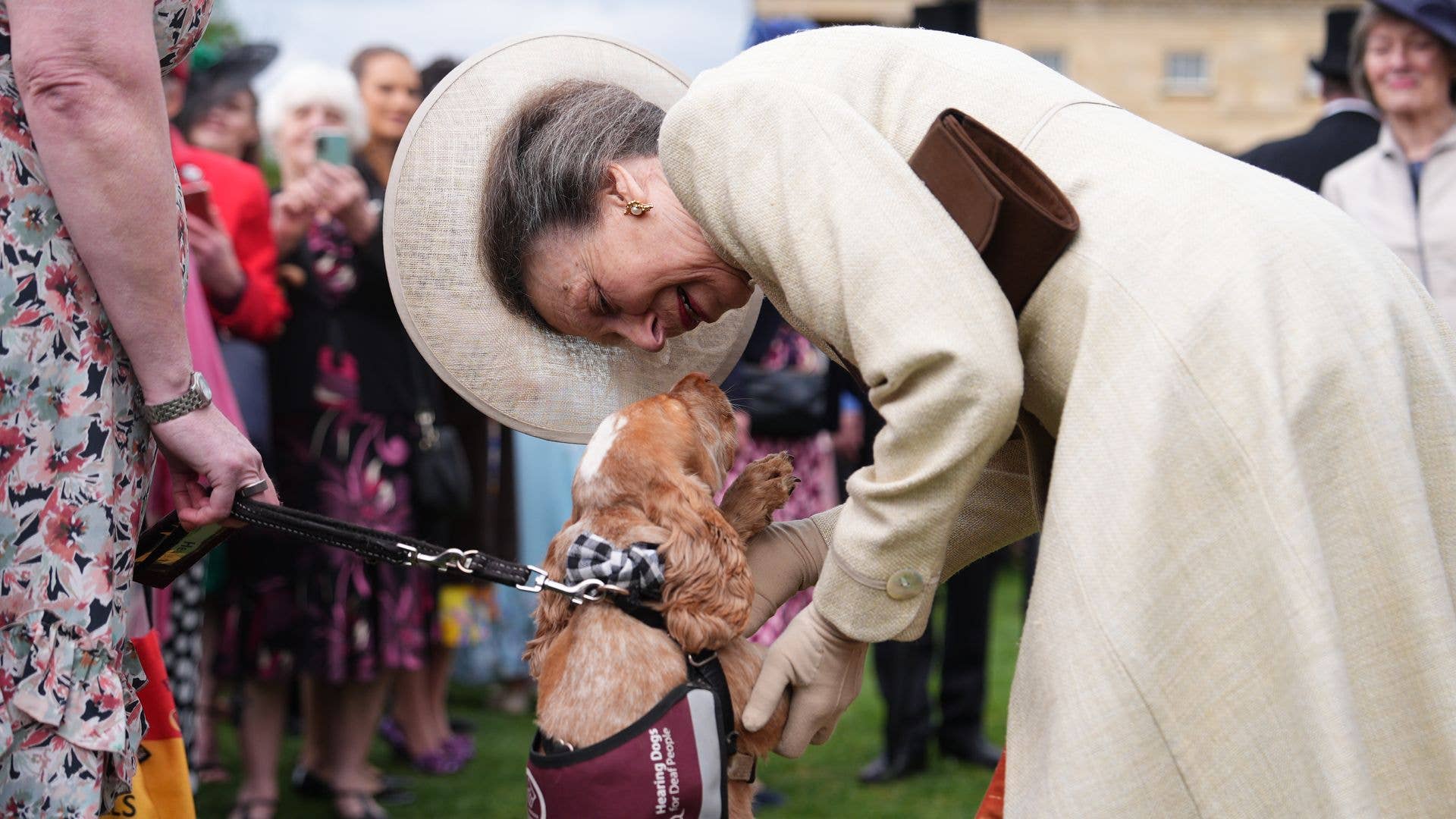 Princess Anne interacting with a puppy on two legs