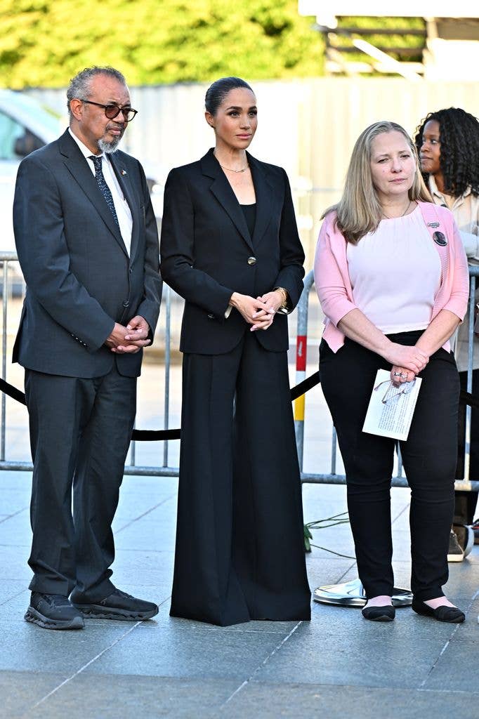 Meghan Markle in black suit beside people