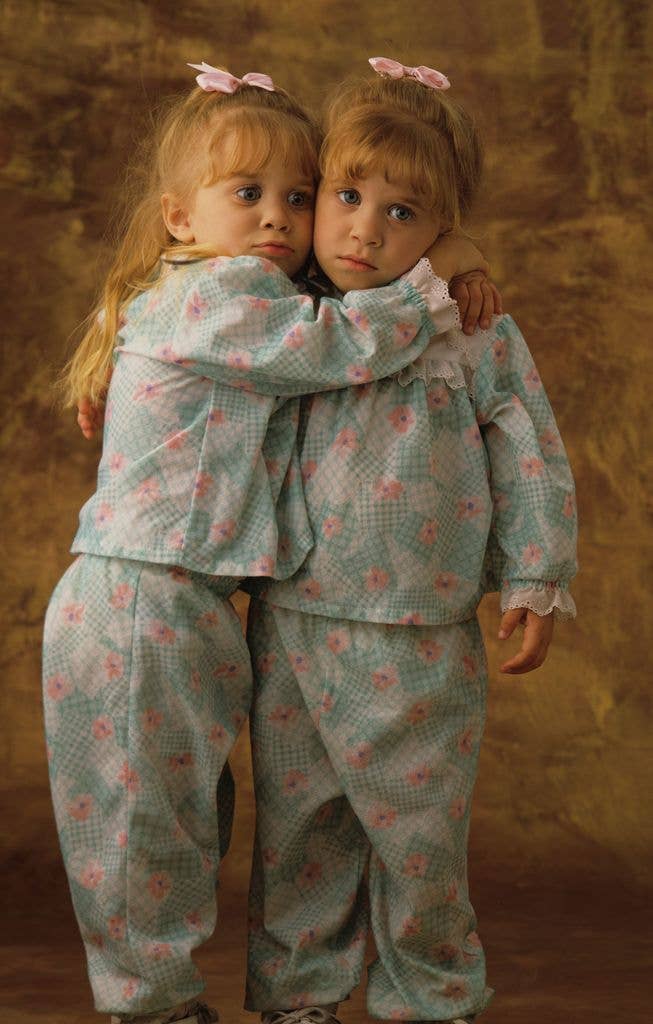 Olsen twins as children in pyjamas with Ashley hugging Mary Kate