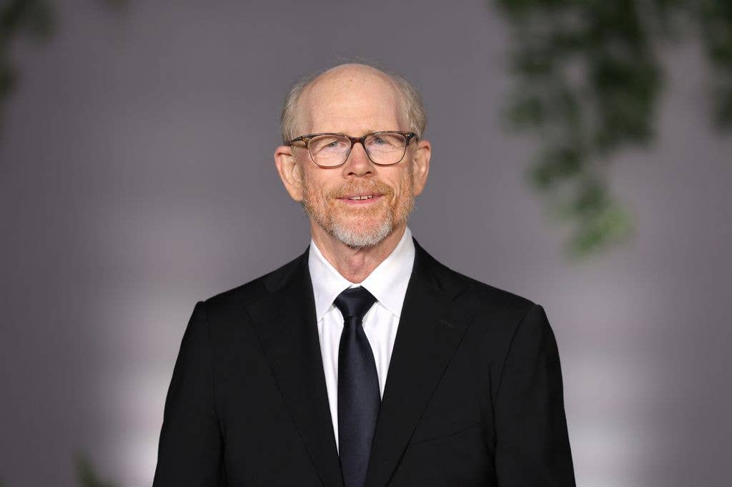 Ron Howard wears a suit with a navy tie. 