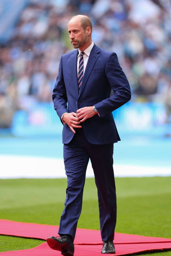 The Prince of Wales in suit on pitch