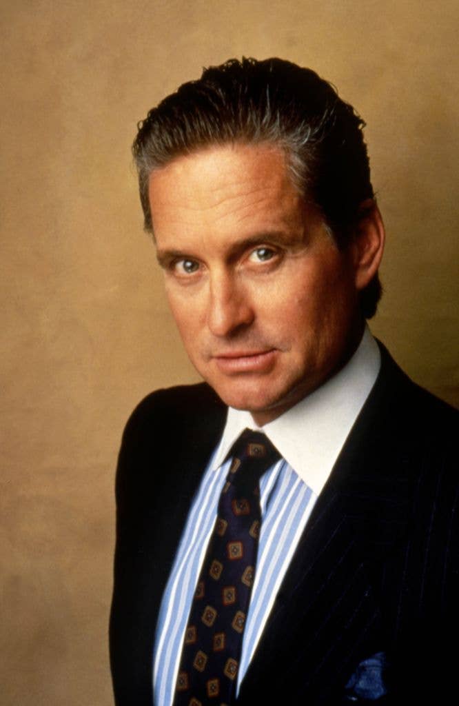 Michael Douglas in a suit and striped shirt on the set of 'Wall Street'.