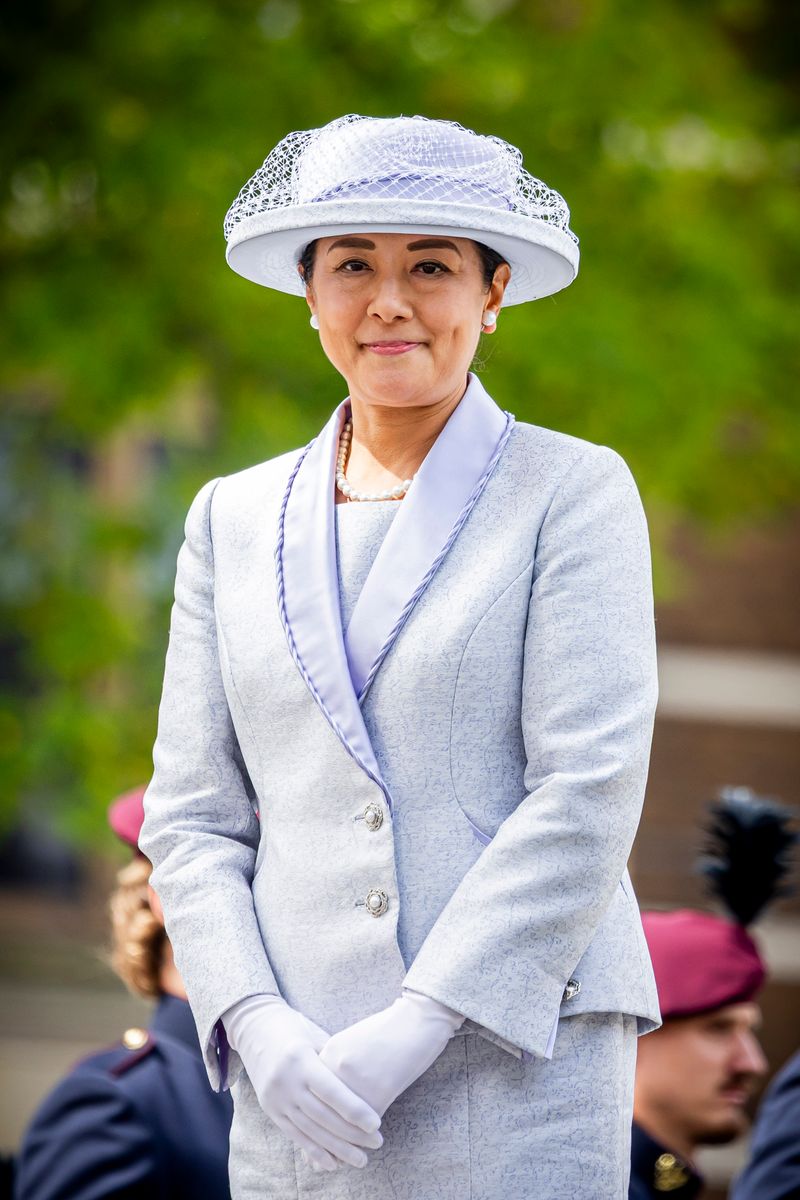Empress Masako embraced timeless imperial elegance in a tailored silk skirt suit, complemented by a matching hat, gloves, and classic pearl jewelry.