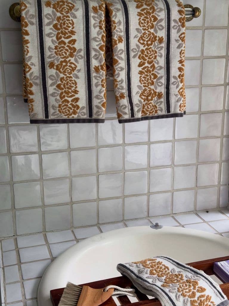 A pretty tiled corner with floral hand towels