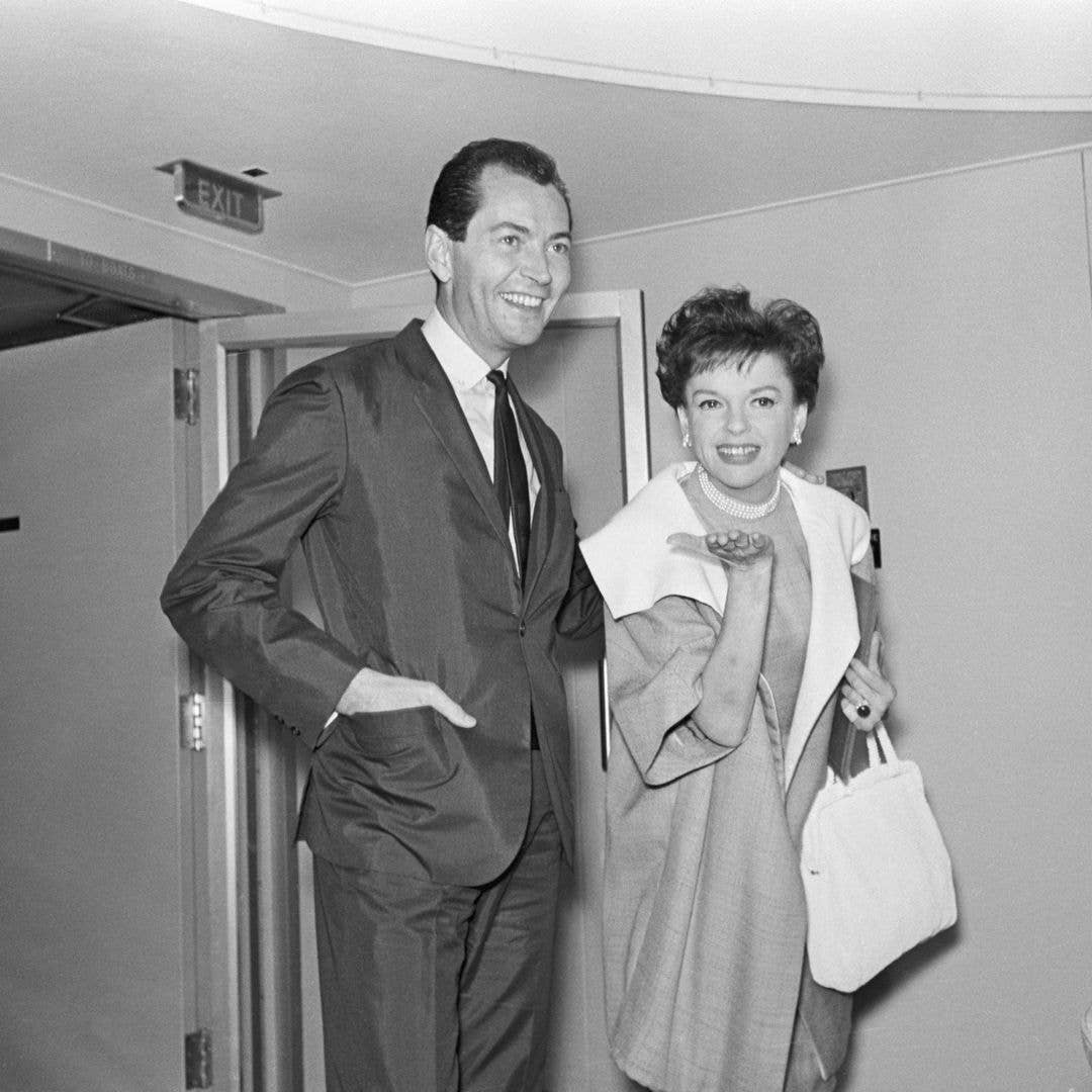 6/16/1964-Yokohama, Japan- Singer Judy Garland and her business manager Mark Herron, who have been making news with the claim that they are married, seem delighted to meet the press as they arrive here, June 16. Miss Garland, who was hospitalized last week, appears to be in fine form.