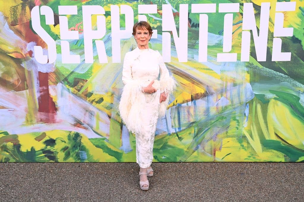 Celia Imrie in cream dress with feathers on sleeves