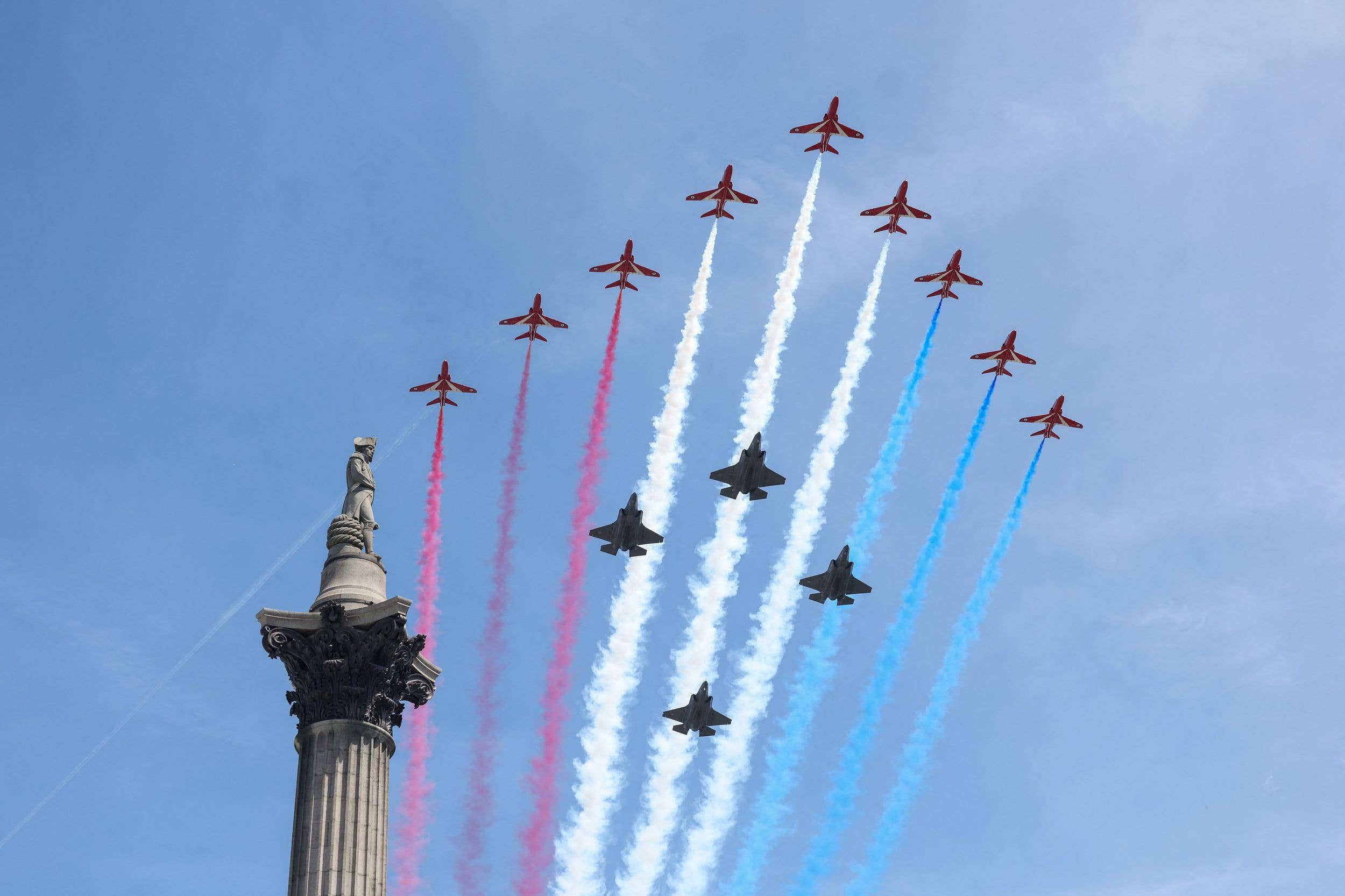 The red arrows and four typhoon jets make a spectacular flypast trailing blue, red and white smoke