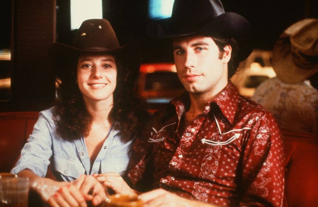 Actor John Travolta and Debra Winger smile on set of the Paramount Pictures movie  'Urban Cowboy" circa 1980.