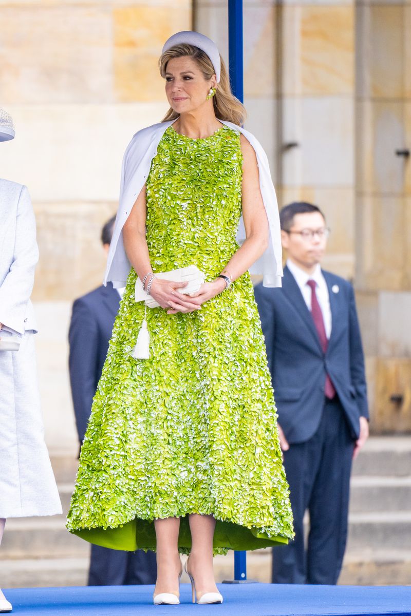 Queen Máxima stood out in a striking lime-green dress covered in three-dimensional floral appliqués that created a dramatic textural effect from neckline to hem.