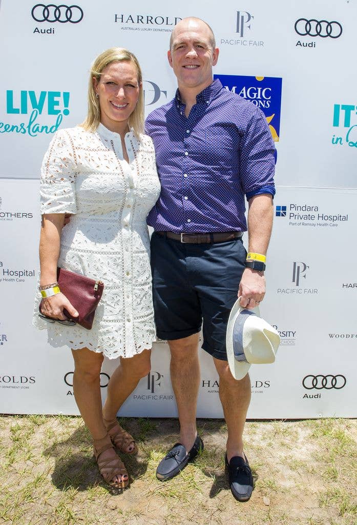Zara in white dress and Mike Tindall in shorts posed outside