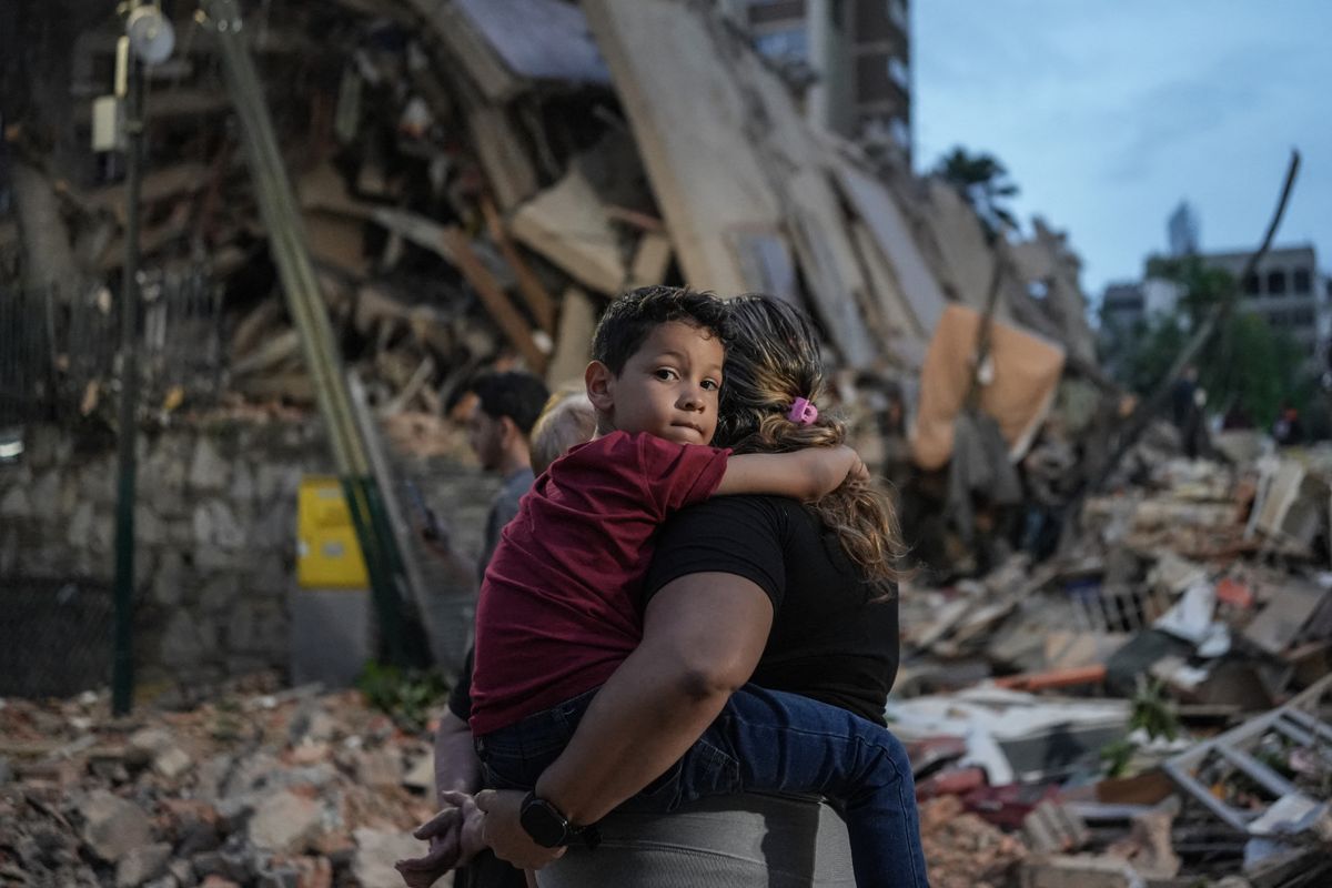 Families and rescue crews gather near collapsed buildings as recovery efforts intensify following the deadly earthquakes.