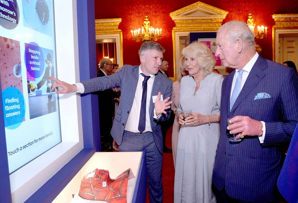 King Charles and Queen Camilla view a Cancer Research UK display