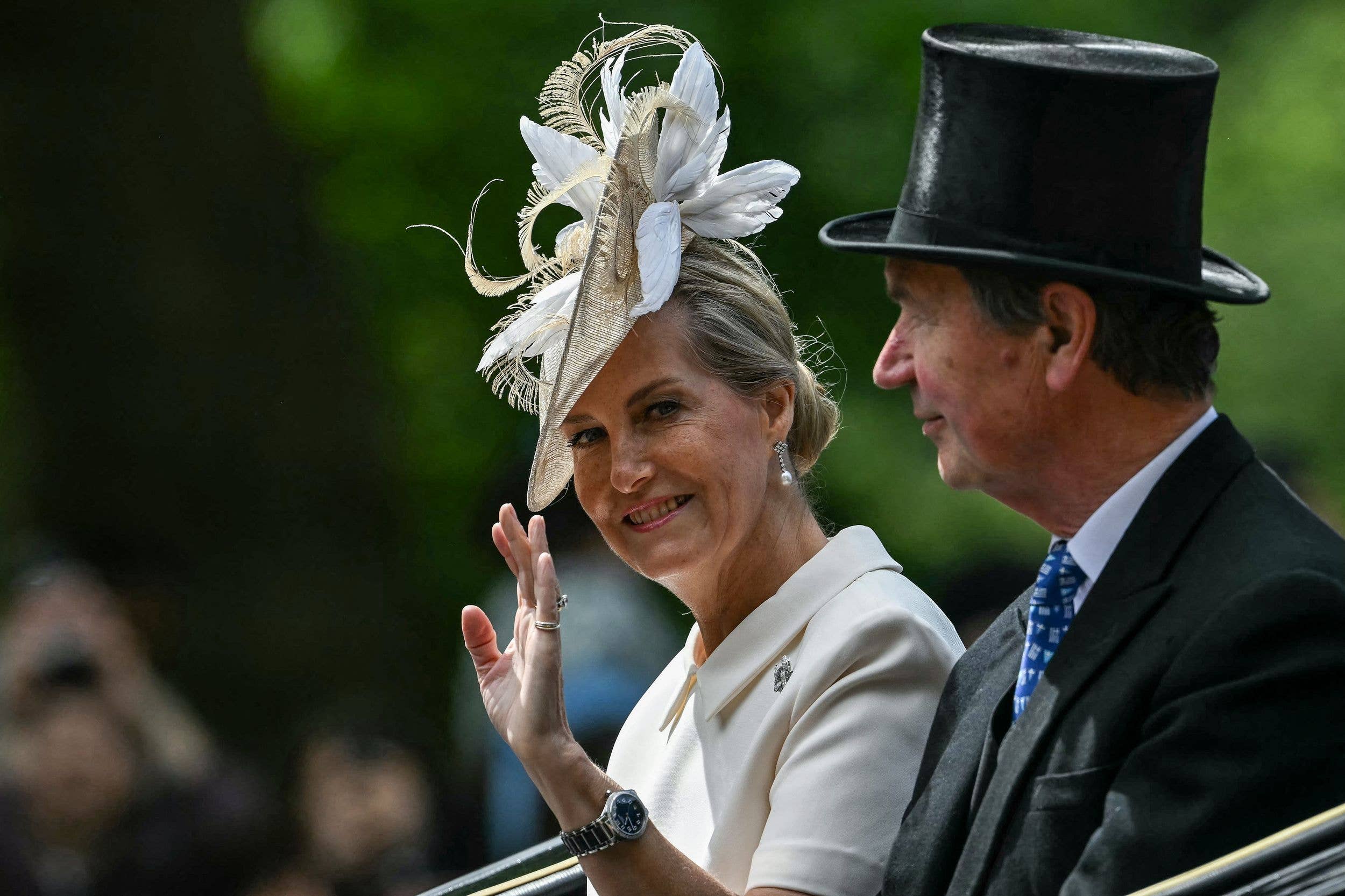 Sitting alongside Vice Admiral Timothy Laurence, the Duchess of Edinburgh waves from the No 1 Barouche