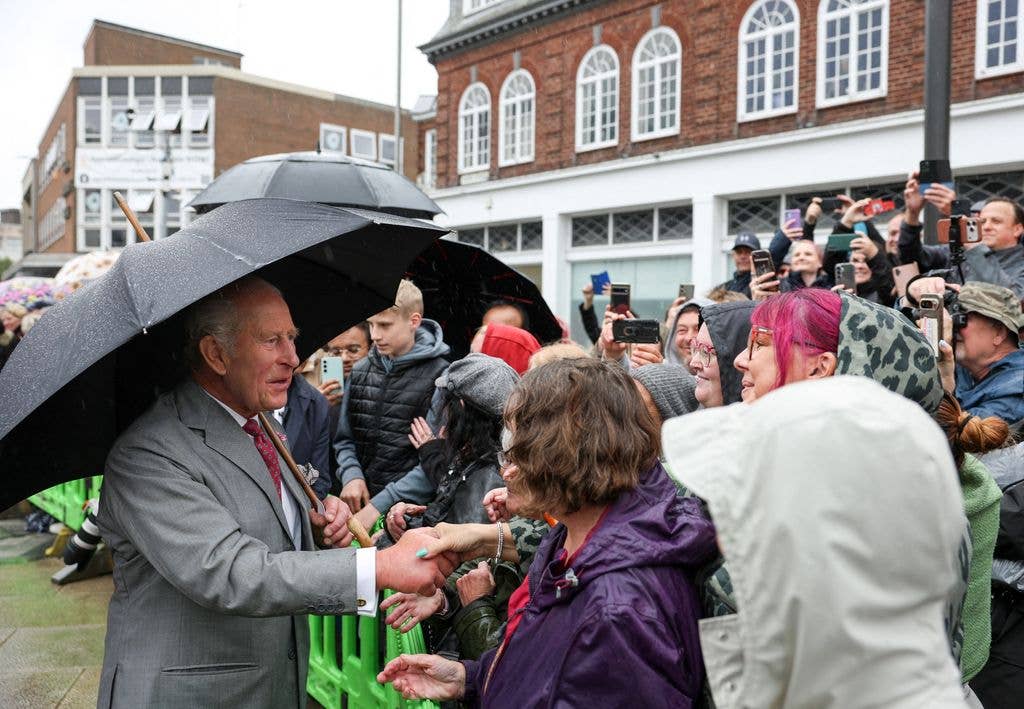Britain's King Charles III greets well-wishers who had waited in the rain in the hope of meeting him, during his visit to Grimsby