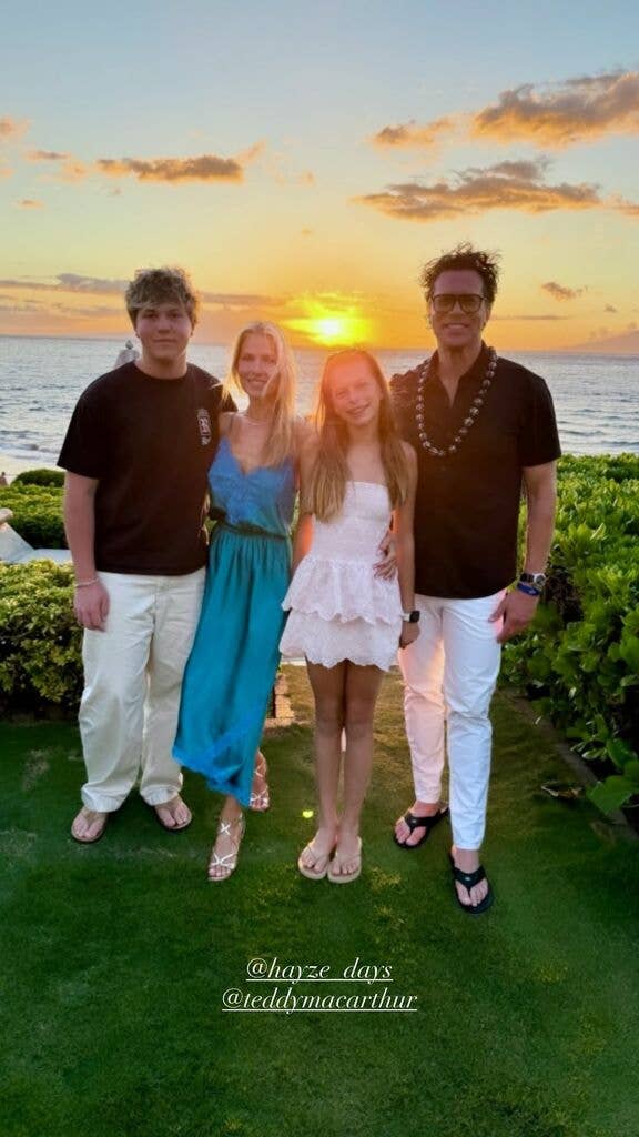 Ali Larter posing with husband and kids in front of ocean at sunset