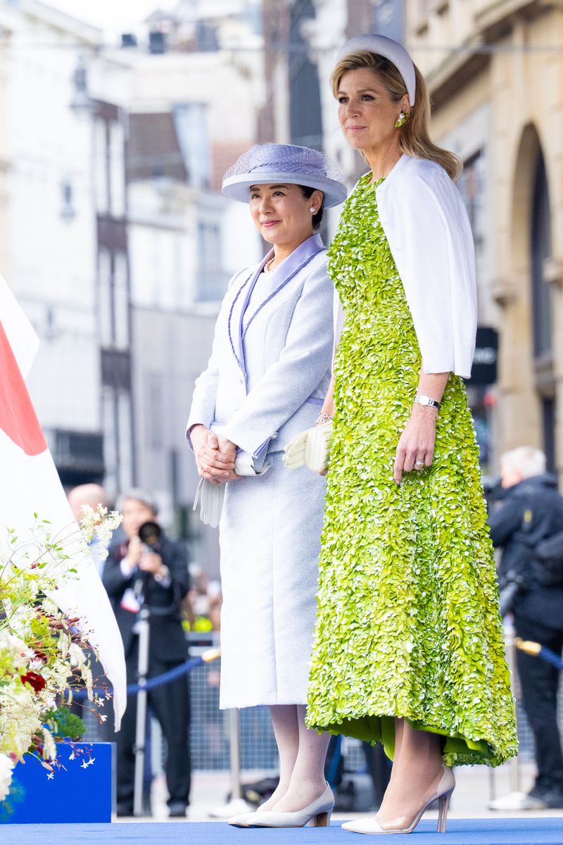 Queen Máxima's striking green ensemble contrasted beautifully with Empress Masako's pale blue silk skirt suit and matching gloves.