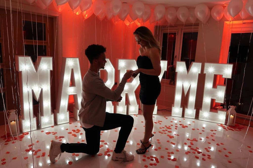 photo of Antonee Robinson on one knee proposing to Darcy Myers