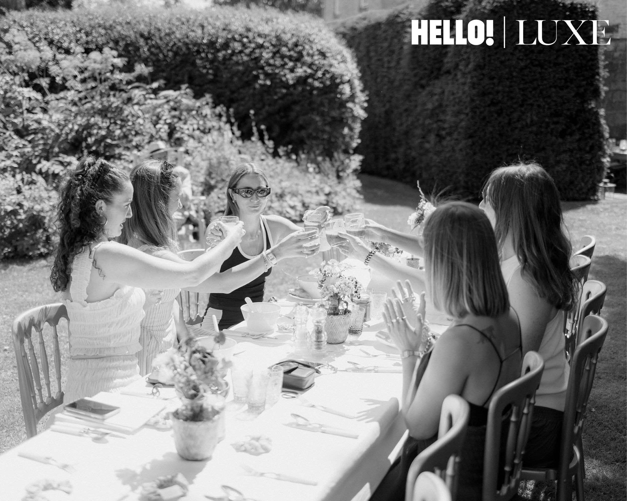 Surrounded by her closest girlfriends, Lady Marina (second left) enjoys a sunny outdoor bridal brunch in the garden before bridal prep begins, raising a glass to toast the exciting day ahead.
