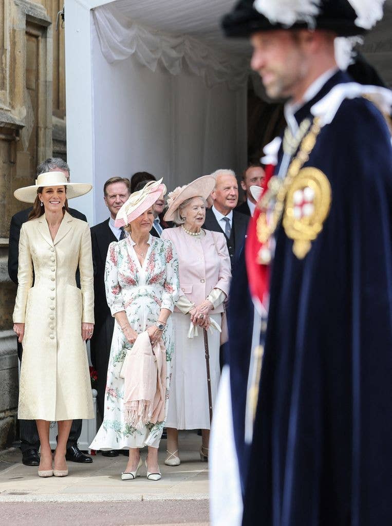 The Princess of Wales (L) smiles as Britain's Prince William, Prince of Wales (front R) walks past 