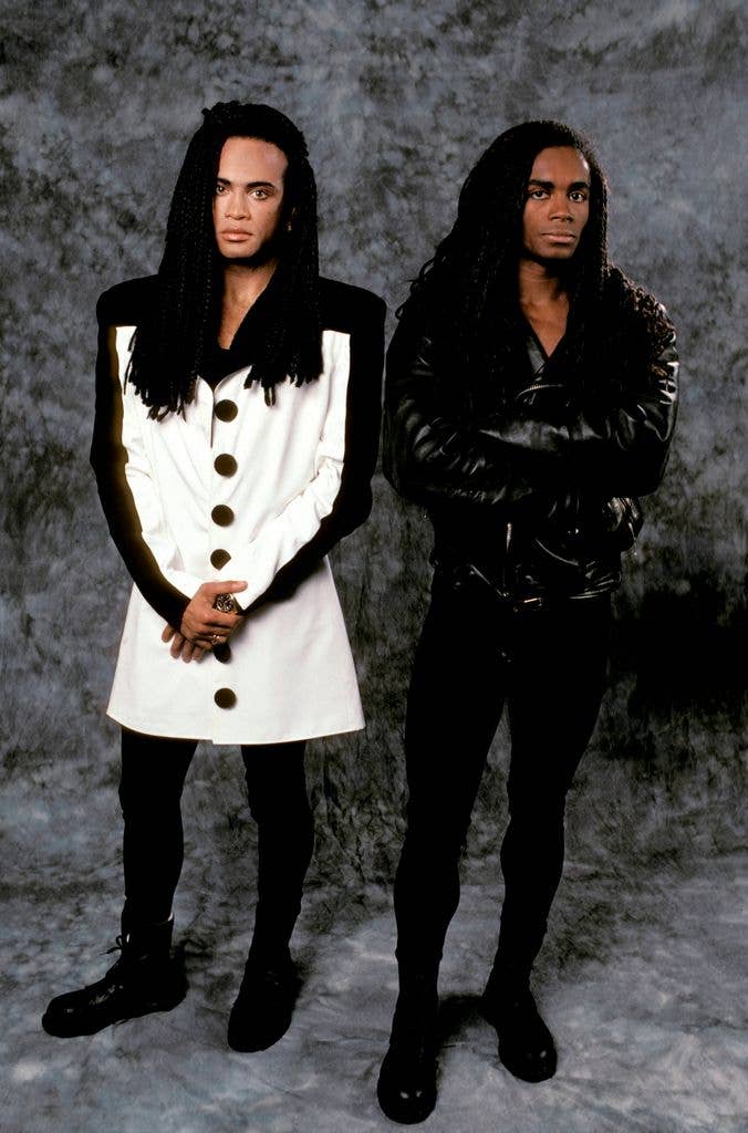 Milli Vanilli pose for a portrait against a mottled grey backdrop in 1990.