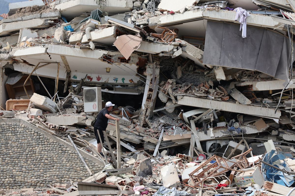 A person searches for victims amid debris of demolished buildings as rescue efforts continue after a magnitude 7.2 earthquake struck Venezuela and other regions in the Caribbean on June 25, 2026, in La Guaira, Venezuela. 