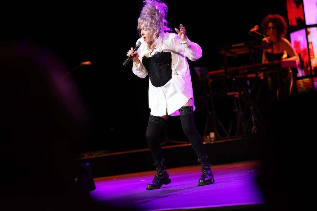 The star wore a white shirt dress with a black corset teamed with black knee-high socks and boots