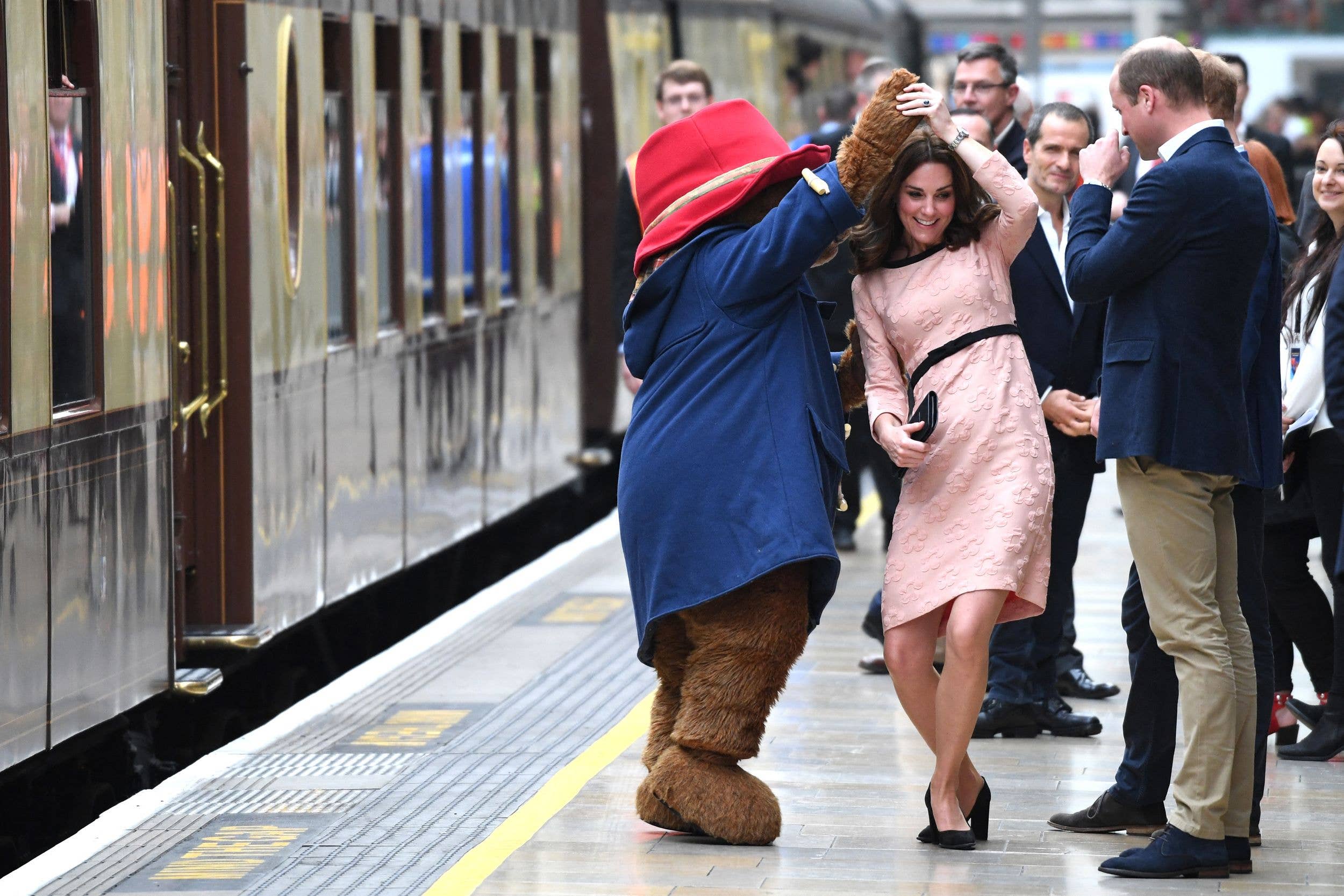 The Princess of Wales takes a quick turn with Paddington on the British Pullman platform in 2017, watched by Prince William