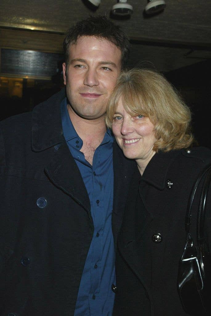 Ben Affleck and a woman in black coats, smiling for a photo.