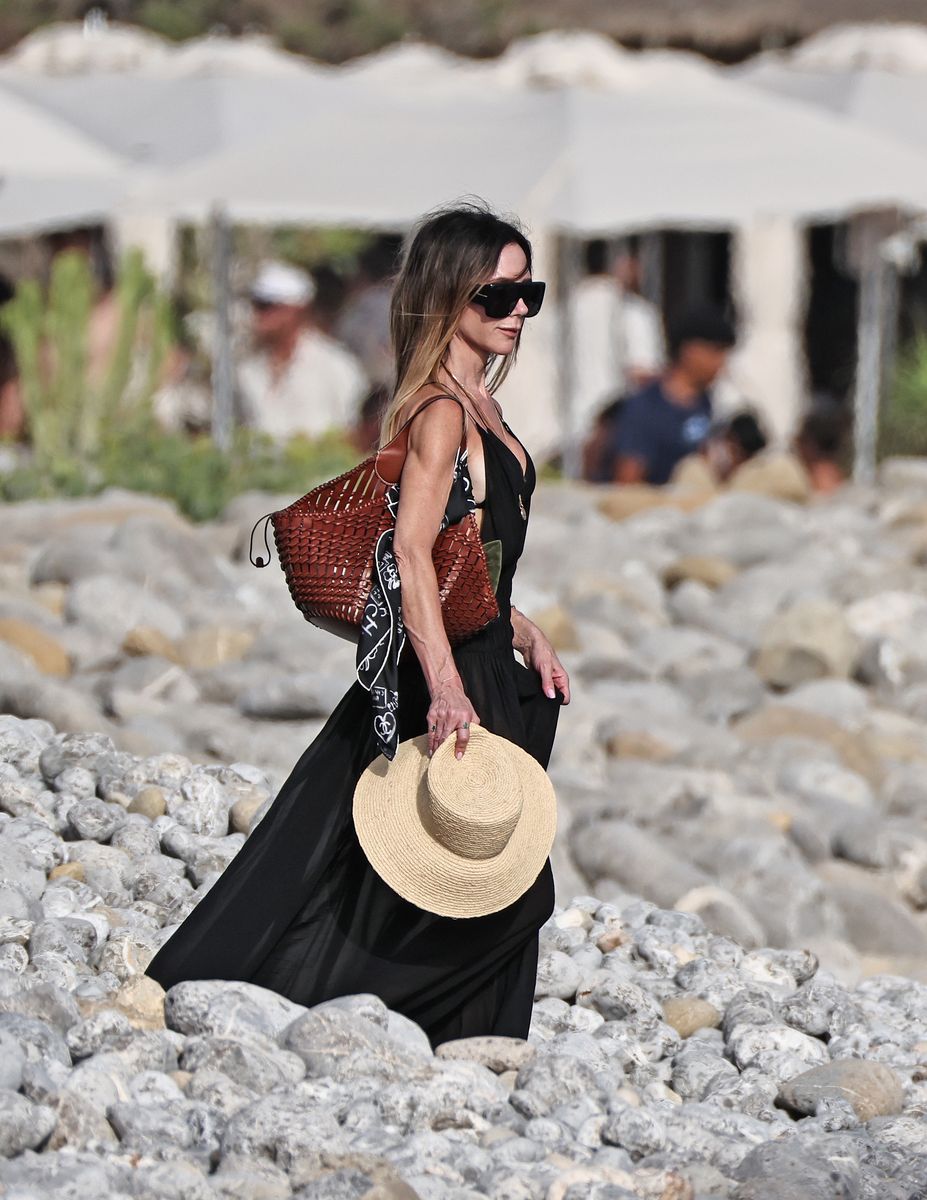 Victoria Beckham keeps it effortlessly chic in a flowing black maxi dress and oversized sunglasses.