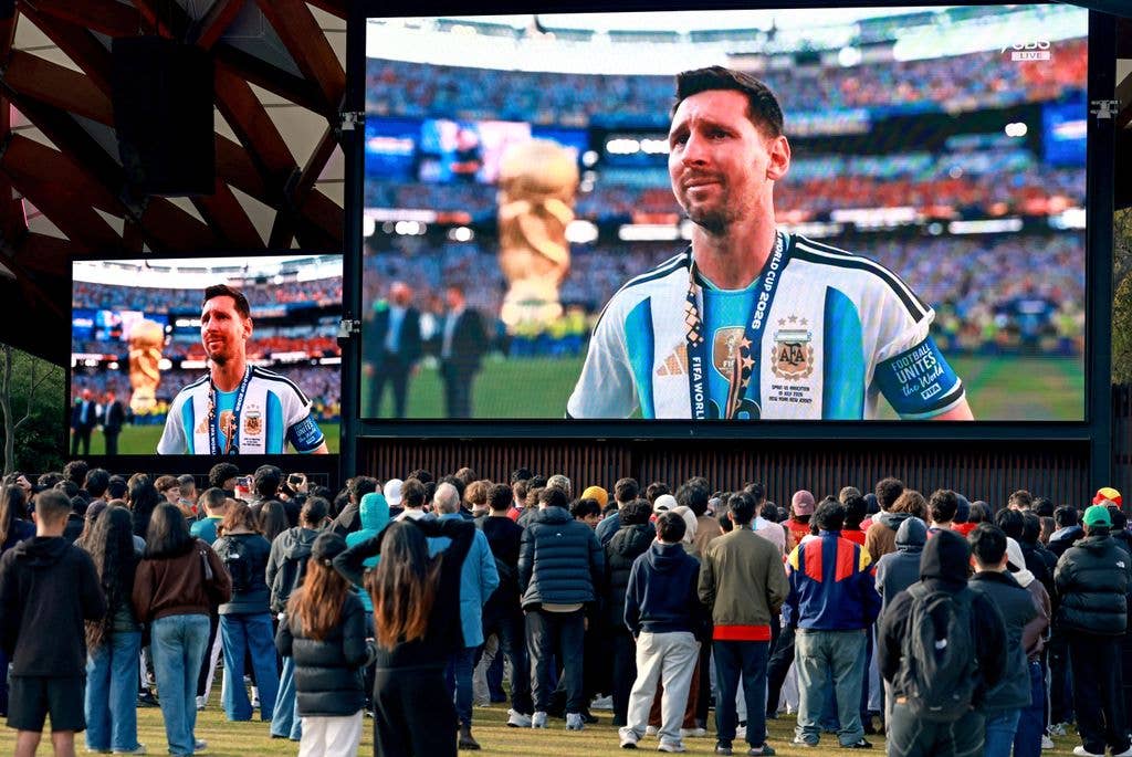 Supporters watch Argentina's Lionel Messi reacting on giant screens in Sydney