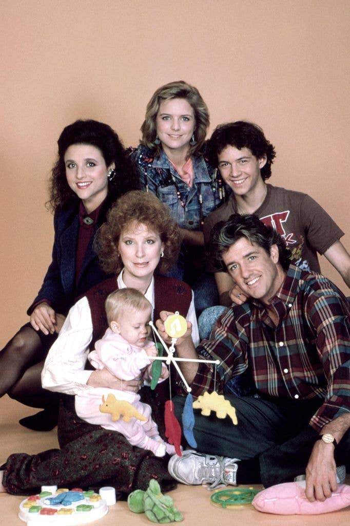 Linda Kelsey and Doug Sheehan with children, one holding a toy, in a family photo.
