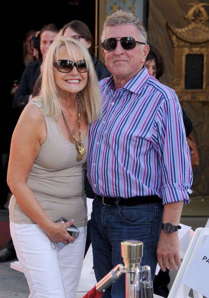 Man and woman standing together at Grauman's Chinese Theatre, both wearing sunglasses.