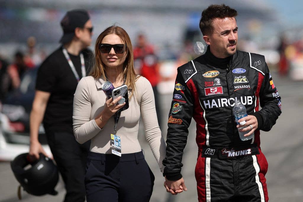 Frankie Muniz, driver of the #30 Hair Club Ford, and wife, Paige Price Muniz walk the grid prior to the ARCA Menards Series BRANDT 200 Supporting Florida FFA at Daytona International Speedway on February 18, 2023 in Daytona Beach, Florida