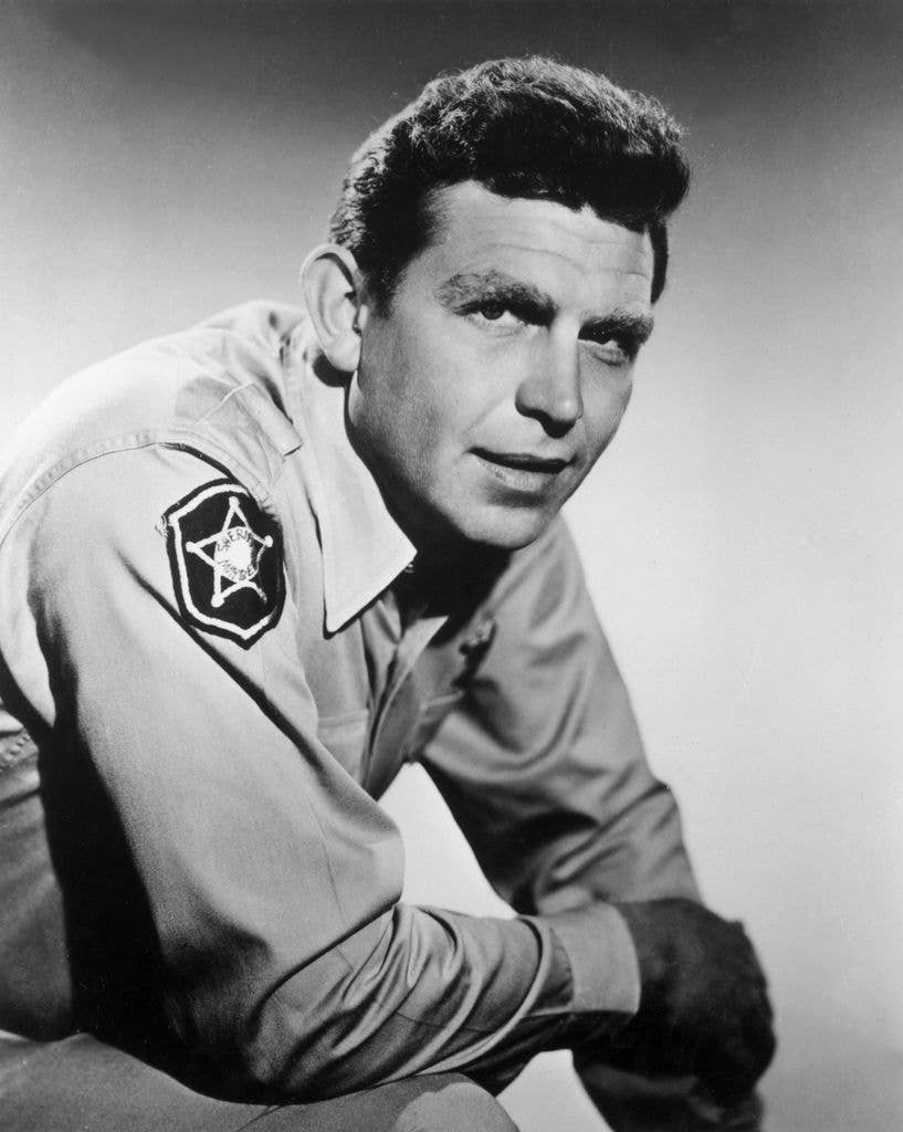 Portrait of American actor Andy Griffith leaning forward and wearing his sheriff's costume from the television series, 'The Andy Griffith Show', dated to around 1962.