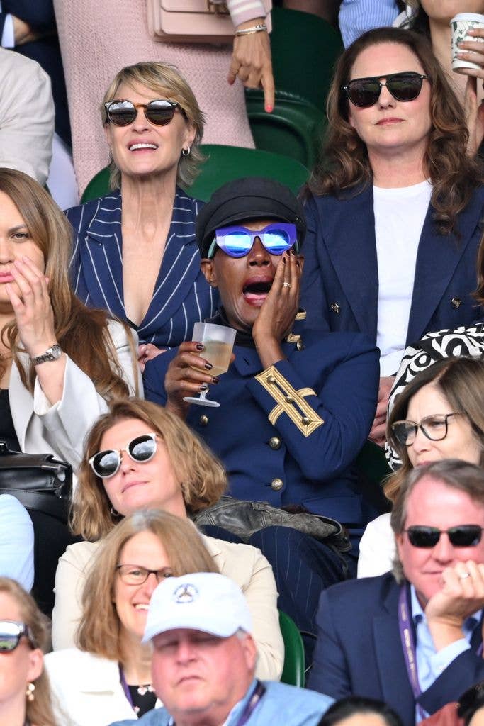 Grace Jones with her hand to her mouth while watching Wimbledon