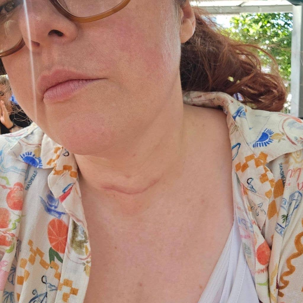 Jenny Ryan with short brown hair and glasses, wearing a colorful shirt, is looking at the camera.