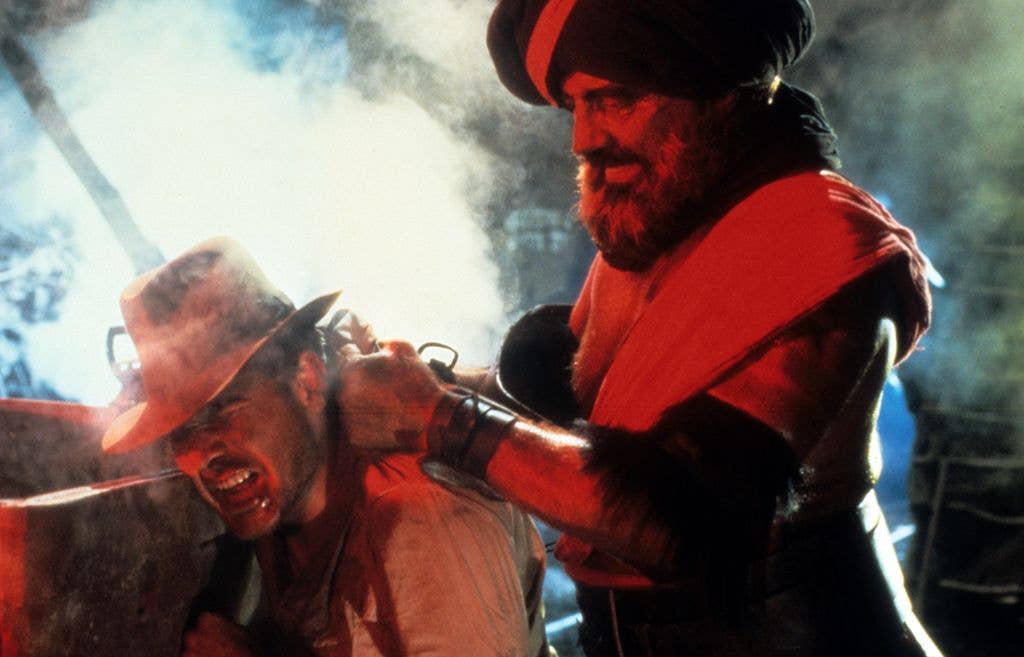 Harrison Ford is threatened with a knife in a scene from the film 'Indiana Jones And The Temple Of Doom', 1984.